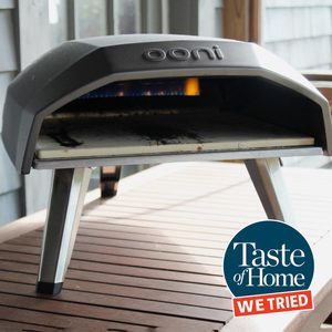 ooni pizza oven on an outdoor table with the taste of home we tried it logo